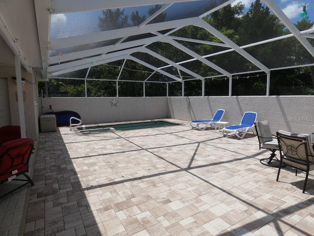 view of swimming pool with glass enclosure and a patio area