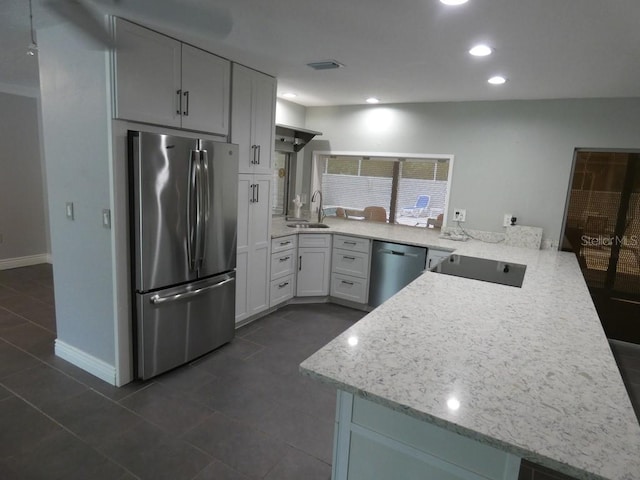 kitchen featuring white cabinets, appliances with stainless steel finishes, sink, kitchen peninsula, and dark tile patterned floors