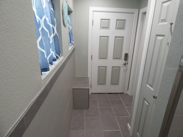 entryway featuring dark tile patterned floors