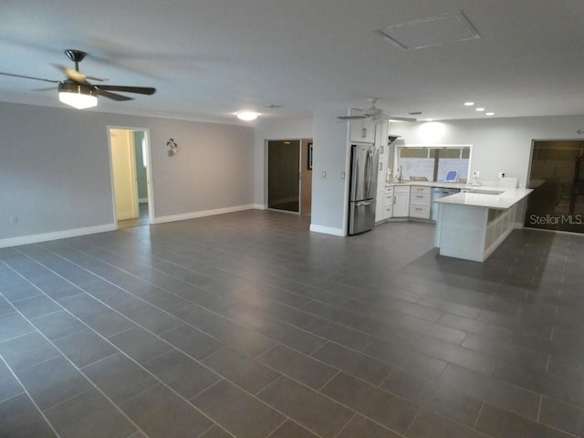 interior space with ceiling fan and dark tile patterned flooring