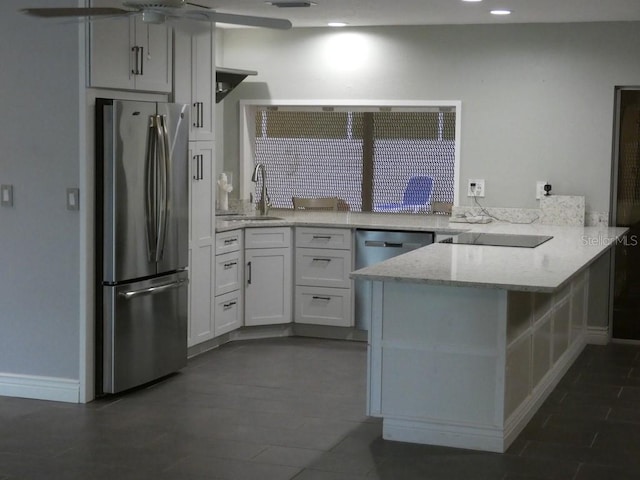 kitchen with white cabinetry, sink, kitchen peninsula, stainless steel fridge, and ceiling fan