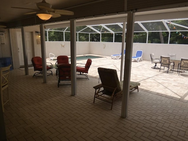 view of patio with ceiling fan, glass enclosure, and a fenced in pool