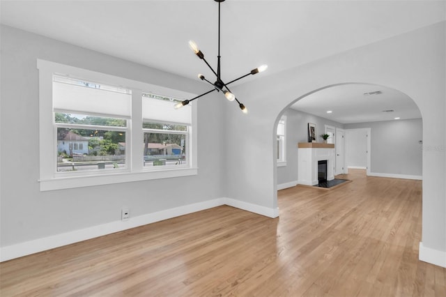 interior space with a tiled fireplace and light hardwood / wood-style floors