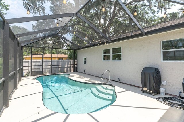 view of swimming pool with glass enclosure and a patio