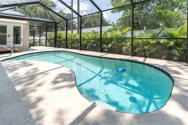 view of swimming pool with a lanai, a patio area, and french doors