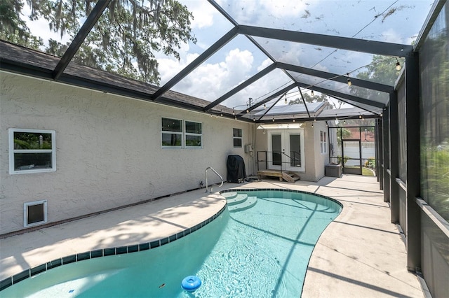 view of swimming pool featuring glass enclosure, french doors, and a patio area