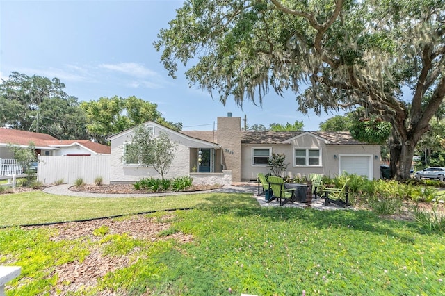 back of property with a garage and a lawn