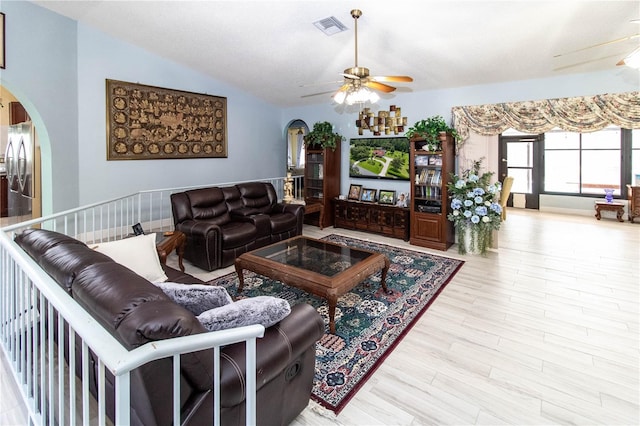 living room with ceiling fan, vaulted ceiling, and light hardwood / wood-style flooring