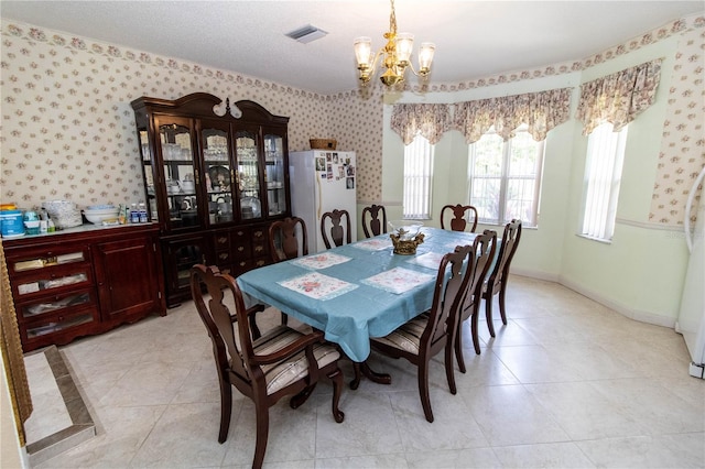 dining space with light tile patterned floors and an inviting chandelier