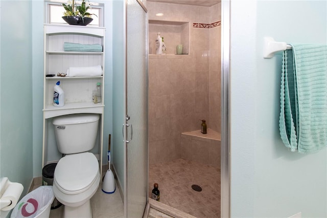 bathroom featuring tiled shower and toilet