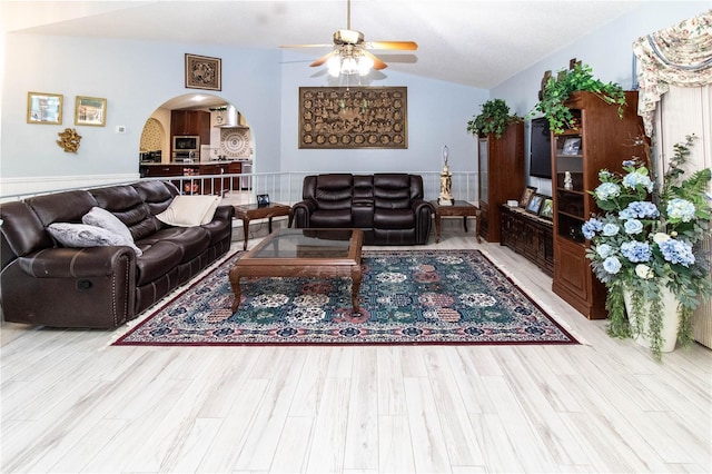 living room featuring ceiling fan, lofted ceiling, and light hardwood / wood-style floors