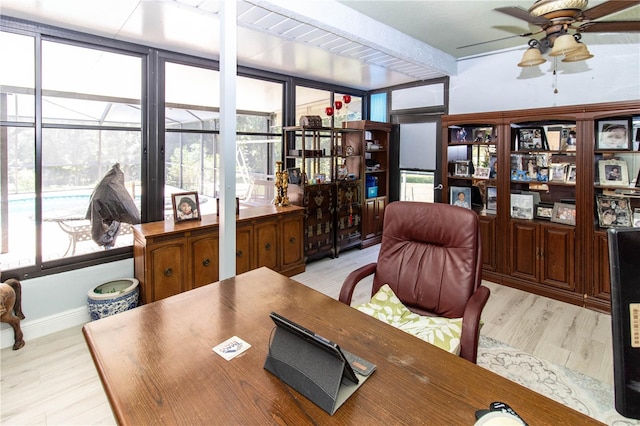 interior space featuring beam ceiling, light wood-type flooring, and ceiling fan