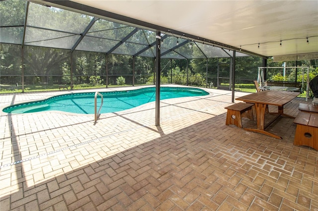 view of swimming pool with glass enclosure and a patio area