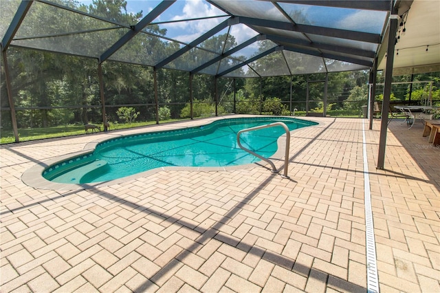 view of swimming pool featuring glass enclosure and a patio area