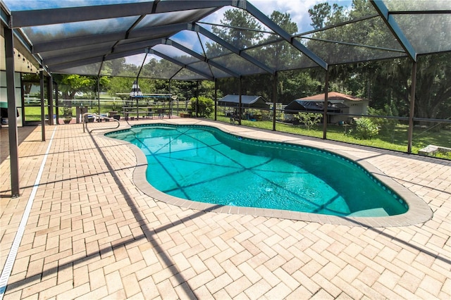 view of swimming pool with glass enclosure and a patio