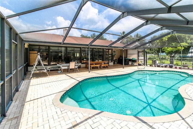 view of swimming pool with a lanai and a patio