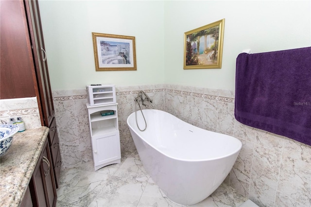 bathroom featuring tile walls, vanity, a washtub, and tile patterned flooring