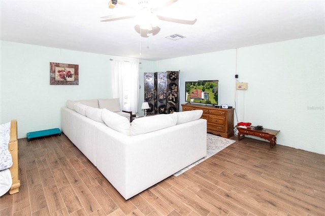 living room featuring hardwood / wood-style floors and ceiling fan