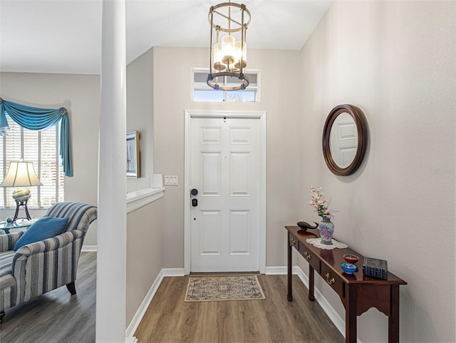 foyer entrance featuring a notable chandelier and dark hardwood / wood-style flooring