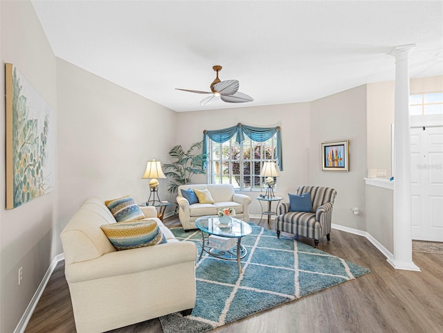 living room with hardwood / wood-style floors, ceiling fan, and ornate columns