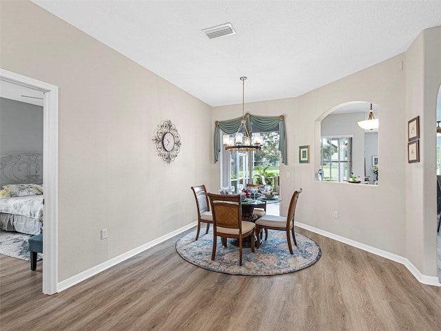 dining space with a notable chandelier and wood-type flooring