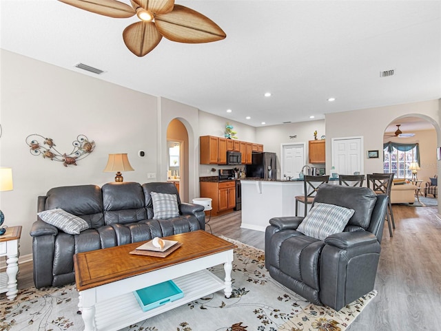 living room with ceiling fan and light hardwood / wood-style floors