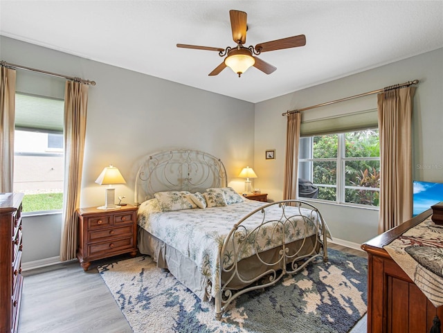 bedroom with light hardwood / wood-style floors and ceiling fan