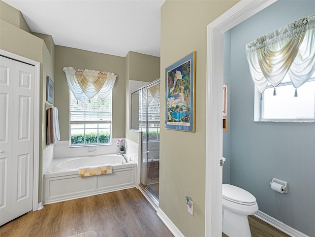 bathroom featuring wood-type flooring, toilet, and separate shower and tub