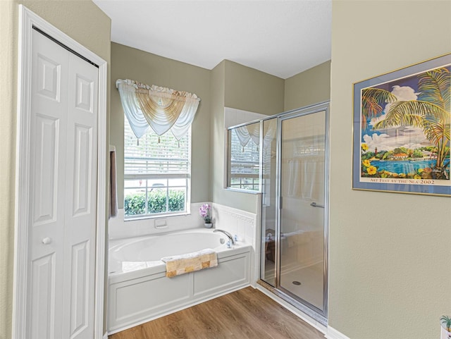 bathroom featuring wood-type flooring and separate shower and tub