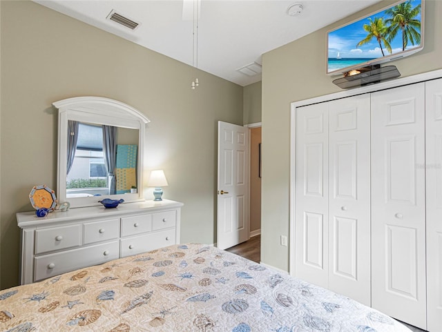 bedroom with dark wood-type flooring, ceiling fan, and a closet