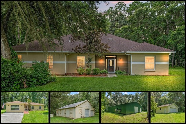 view of front of property featuring a garage, a yard, and an outdoor structure