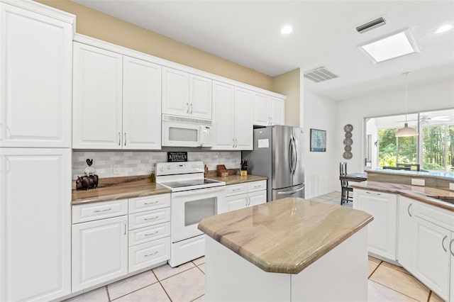 kitchen with a center island, tasteful backsplash, visible vents, white cabinets, and white appliances