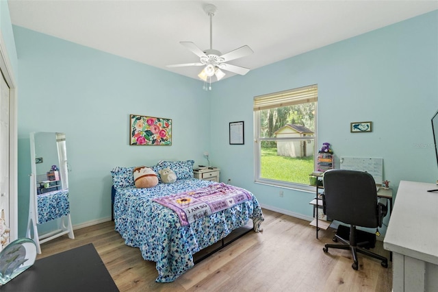 bedroom with light wood-style floors, ceiling fan, and baseboards