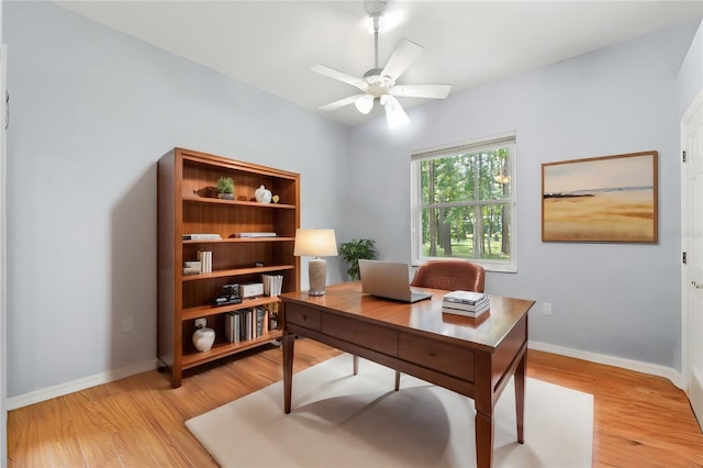 office area with baseboards, ceiling fan, and light wood finished floors