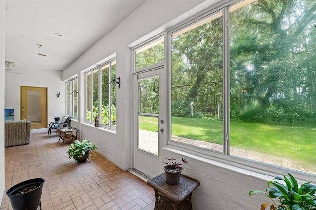 doorway featuring brick floor and a sunroom