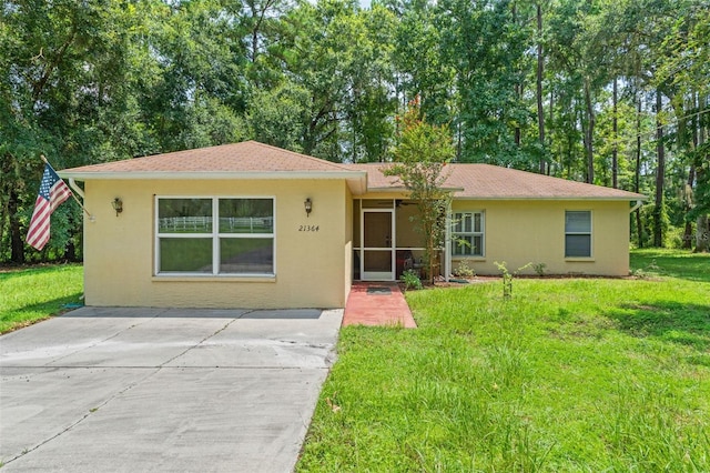 single story home with a front lawn and stucco siding