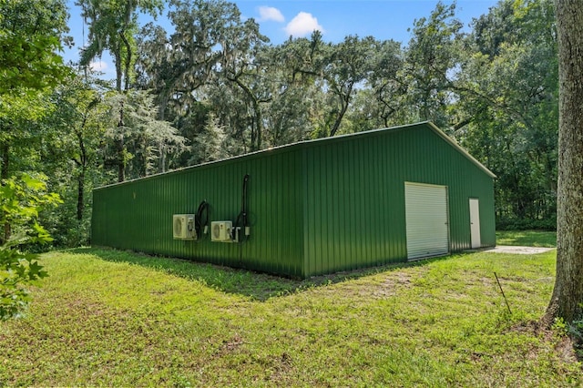 view of pole building with driveway and a lawn