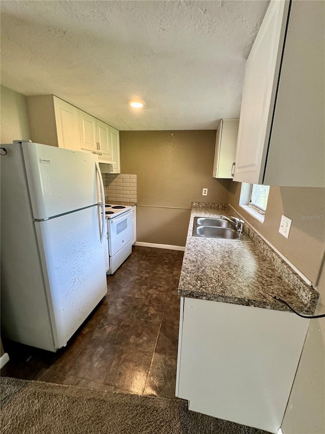 kitchen with dark tile patterned floors, white cabinetry, backsplash, white appliances, and sink