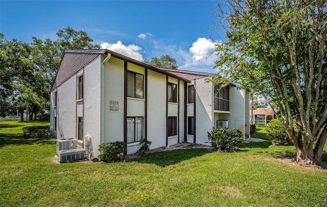 view of front of property with central AC unit and a front lawn