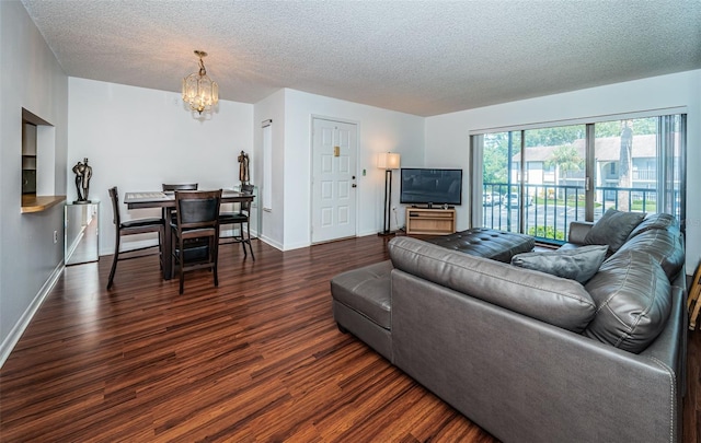 living room featuring a textured ceiling, dark hardwood / wood-style flooring, and a chandelier