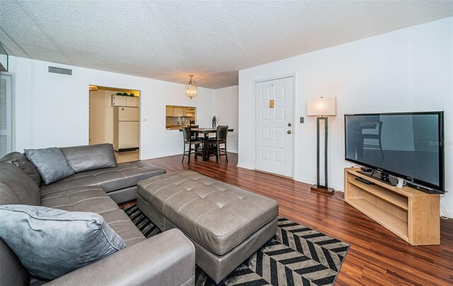 living room featuring dark hardwood / wood-style flooring and a textured ceiling