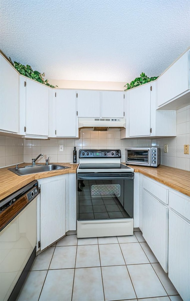 kitchen with white cabinets, tasteful backsplash, white appliances, and premium range hood