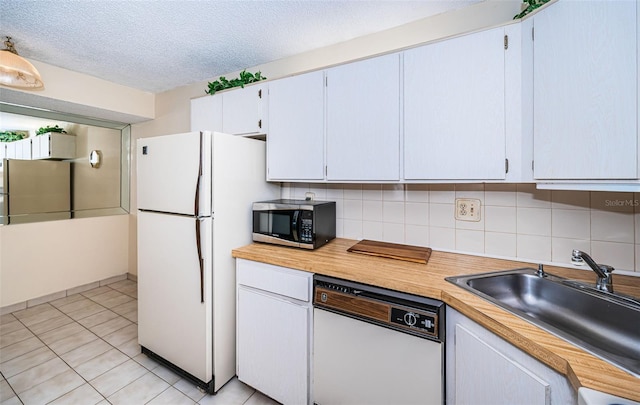 kitchen with a textured ceiling, appliances with stainless steel finishes, backsplash, white cabinets, and sink