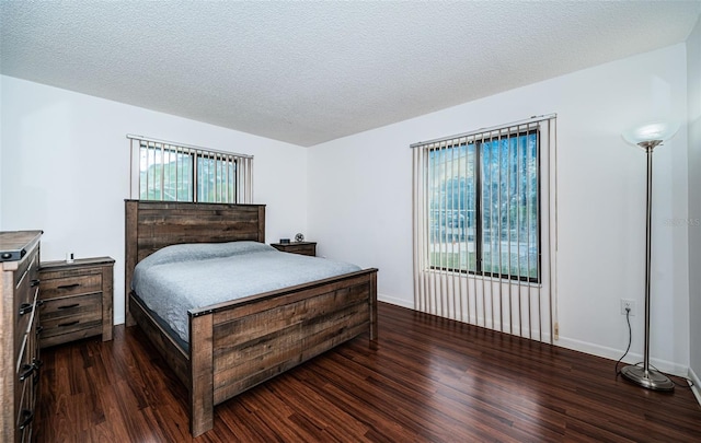 bedroom with a textured ceiling and dark hardwood / wood-style floors