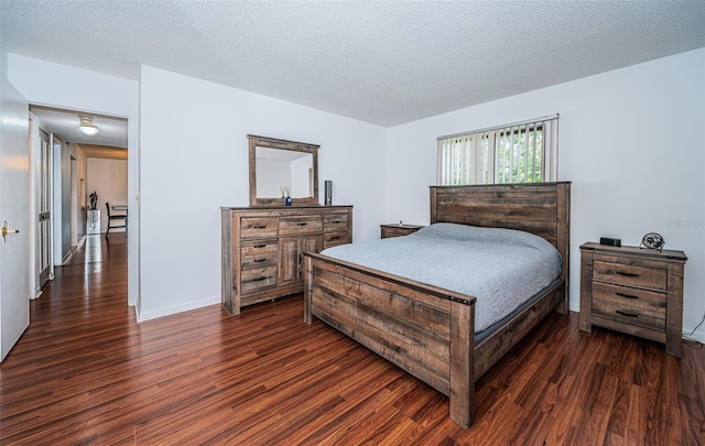 bedroom with a textured ceiling and dark wood-type flooring