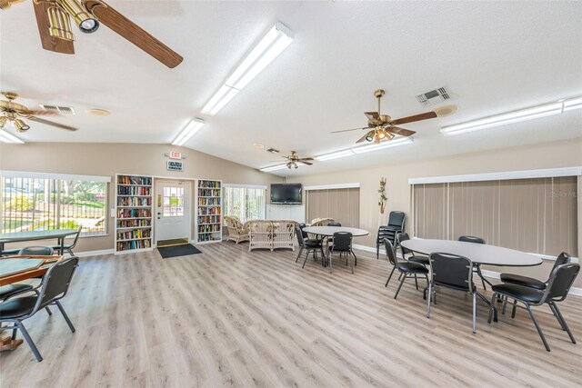 interior space with ceiling fan, vaulted ceiling, and light hardwood / wood-style floors