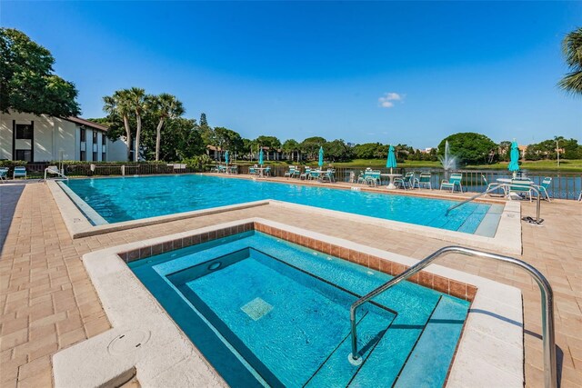 view of swimming pool with a patio and a hot tub