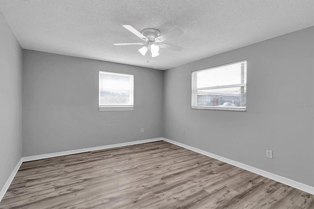 empty room featuring ceiling fan, light hardwood / wood-style floors, and a textured ceiling