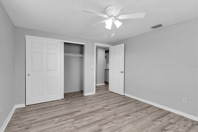 unfurnished bedroom with ceiling fan, a textured ceiling, and light hardwood / wood-style flooring