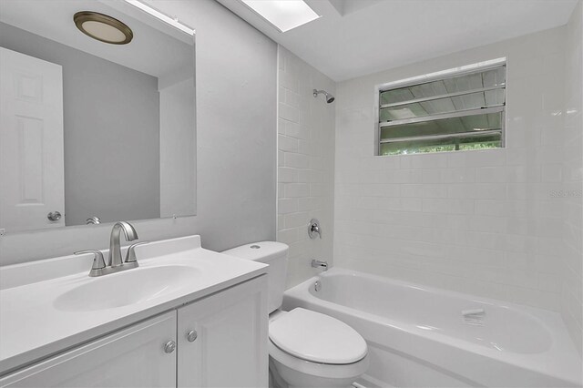 full bathroom with vanity, toilet, and tiled shower / bath combo